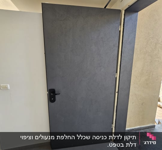 דלת אפורה עם ידית שחורה במסגרת קיר בהיר